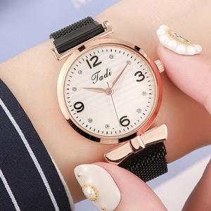 Detail of a ladies' fashion watch with rose gold case and black Milanese magnetic strap