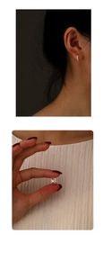 Detail showing mini S925 silver star hoop earring size and fit on a model ear