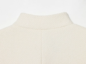 Detail of cream standing collar jacket showing high-quality tweed texture and stitching