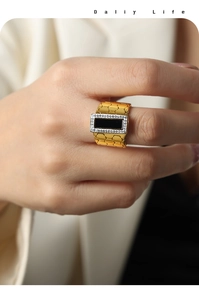 Macro detail of 18k gold hexagonal lattice ring featuring black stone and zircon border