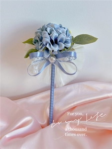Detail of blue faux silk flower pen with lace, pearls and satin ribbon for weddings