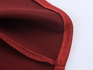 Macro detail of wine red knitted dress showing premium double stitching and hem finish