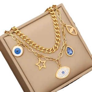 Gold layered stainless steel necklace with evil eye and star charms on jewelry box