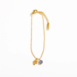 Detailed macro shot of Virgo zodiac charm and light blue zircon on golden steel bracelet