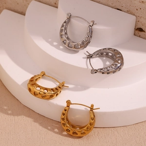 Detailed view of hollow heart pattern U-shaped earrings in gold and silver finishes