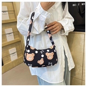 Detail of cute teddy bear pattern and white polka dots on black nylon shoulder bag