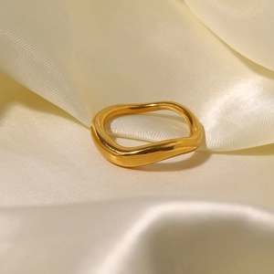 Détail d'une bague plaqué or 18K au design ondulé sur tissu en soie blanche
