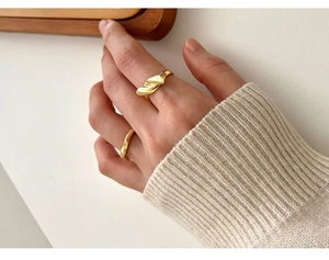 Close-up of gold 925 sterling silver knot ring and minimalist thin band on hand