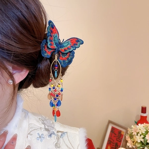 Detail of butterfly embroidery hair clip with silk tassels and beaded metal pendants