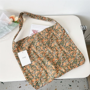 Detailed close-up of a floral canvas tote bag featuring orange flowers and a MISS brand tag