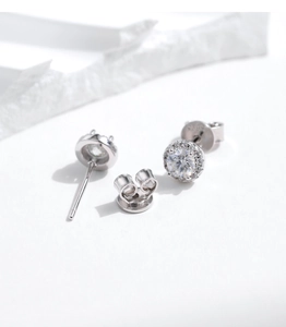 Macro detail of sterling silver halo stud earrings with round moissanite and secure backings