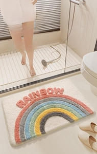 Detailed view of plush rainbow bath mat with high water absorption and anti-slip backing