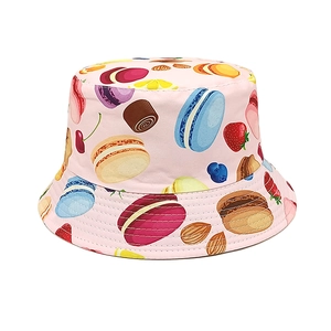 Detailed close-up of pink bucket hat with colorful macaron and strawberry dessert prints