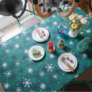 Nappe de Noël verte avec flocons de neige blancs sur une table à manger rectangulaire