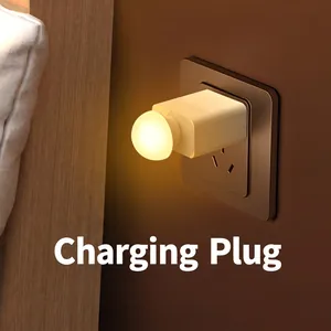 Portable USB night light with warm LED glow plugged into a modern wall socket