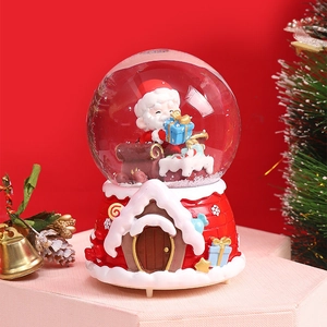 Macro detail of Christmas snow globe featuring Santa, sleigh, and candy house base