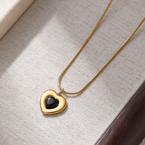 Collana in acciaio al titanio dorato con ciondolo a cuore e inserto nero su portagioie