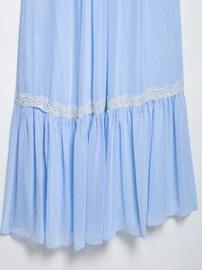 Detail of light blue pleated chiffon hem featuring white lace patchwork and floral texture