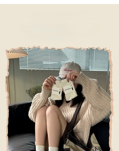 Detail of cream white ribbed knit crew socks featuring soft texture and branded packaging