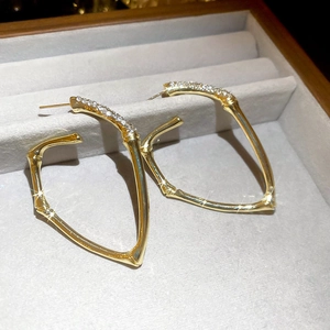 Luxurious gold bamboo-style geometric hoop earrings with sparkling pave-set crystal detail