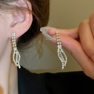 Detailed view of elegant gold leaf tassel earrings with sparkling rhinestones for women