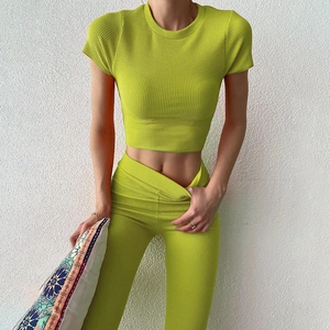 Dettaglio della tuta sportiva verde brillante a coste con crop top e leggings a vita alta