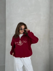 Oversized burgundy half-zip sweatshirt with British heritage print on model