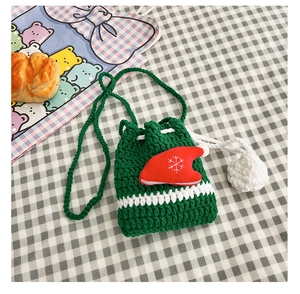 Detail of green handmade knitted reindeer bag with white stripes and snowflake embroidery