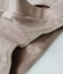 Macro shot of high-elasticity ribbed cotton fabric and reinforced stitching on mauve panties