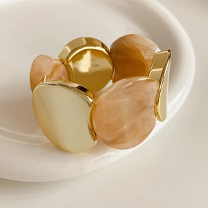 Macro shot of gold-plated metal and marble texture resin segments on a flexible ring