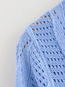 Détail rapproché du tricot bleu clair avec motifs ajourés et texture délicate