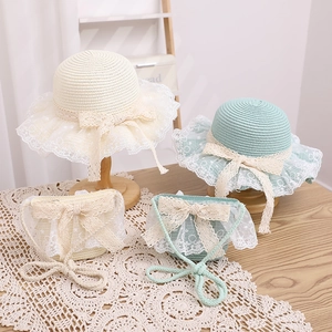 Detail of girls straw sun hat set with elegant white lace trim and sweet bows