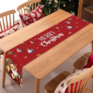 Red Merry Christmas table runner with Santa Claus and snowflake motifs on wooden table