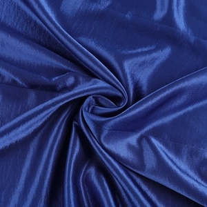 Detail of high-gloss dark blue satin fabric with elegant pleated texture and silky finish