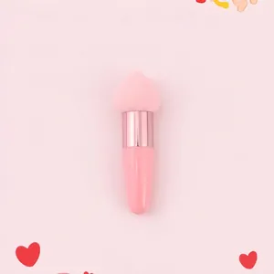 Macro shot of heart-shaped makeup sponge brush with pink handle and rose gold metal ferrule