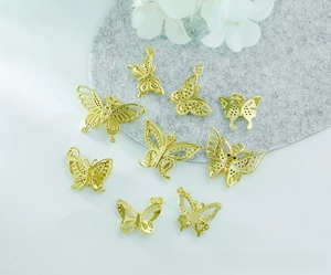 Detail of 18K gold plated copper butterfly charms with intricate cutout designs for DIY