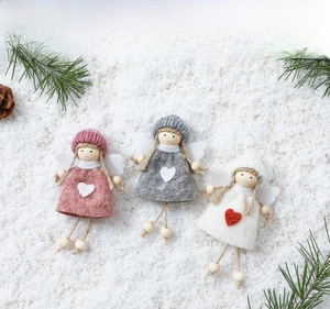 Close-up of handmade knitted Christmas tree angel pendants with heart details and wooden beads