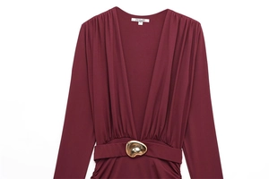 Detail of burgundy V-neck dress featuring pleated waist and elegant gold metal buckle accent