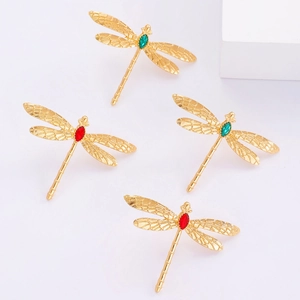 Détails de boucles d'oreilles libellule en métal doré texturé et pierres précieuses marquise