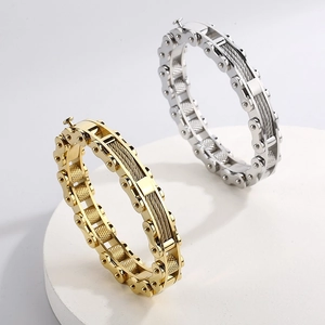 Detailed view of industrial style steel cable and bike chain bracelets in gold and silver