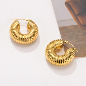 Detail of 18K gold-plated chunky C-shaped hoop earrings with spiral croissant texture