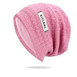 Detailed view of pink knitted beanie featuring wave texture and white KIZLANC brand label