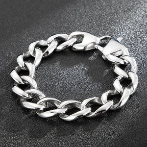 Macro shot of silver-toned Cuban link bracelet with high-polish finish on black background