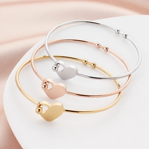 Fashionable interlocking heart bangles in polished gold, silver, and rose gold finishes