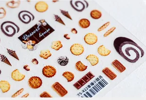 Vista macro di adesivi per unghie 5D a tema dessert con biscotti e cioccolato