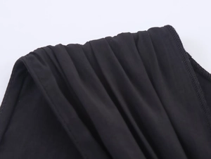 Makroaufnahme von schwarzem Stoff mit eleganten Falten und detaillierter Schulterstruktur