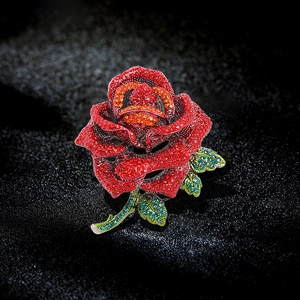 Exquisite rose flower brooch with red gradient rhinestones and green leaves on black background