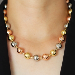 Three-tone beaded necklace in gold, silver, and rose gold finishes on a model
