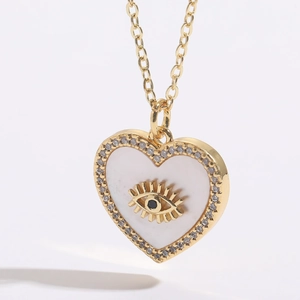 Macro view of gold-plated heart pendant with evil eye shell and white cubic zirconia