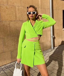 Detail of neon green lace-up cropped jacket and slim skirt with premium draped texture